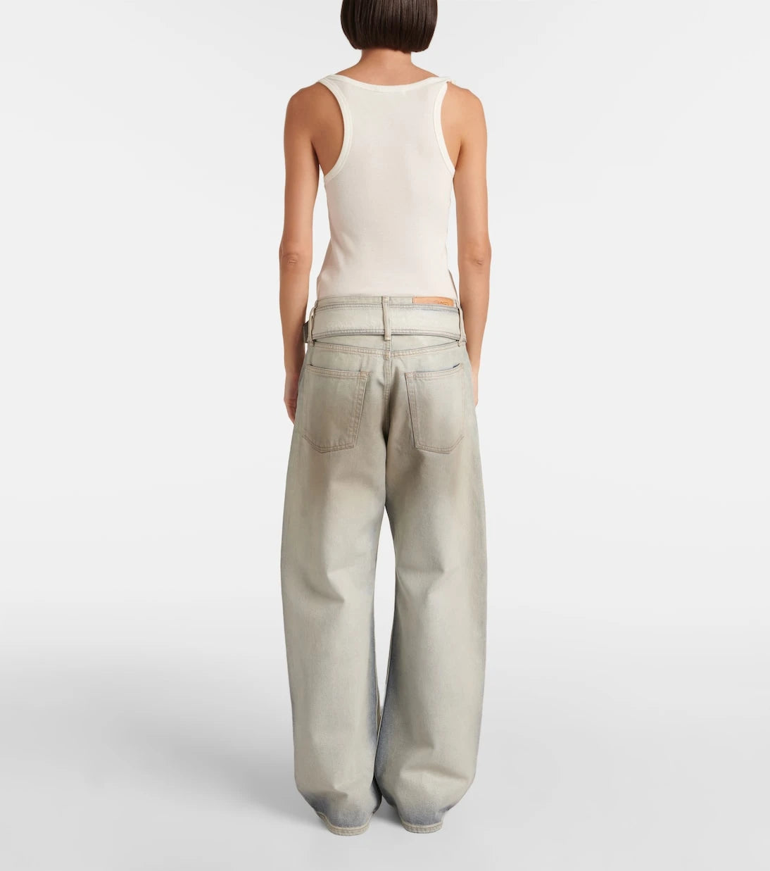 Acne Studios - بنطال جينز واسع بخصر منخفض ومغطى بطبقة لامعة