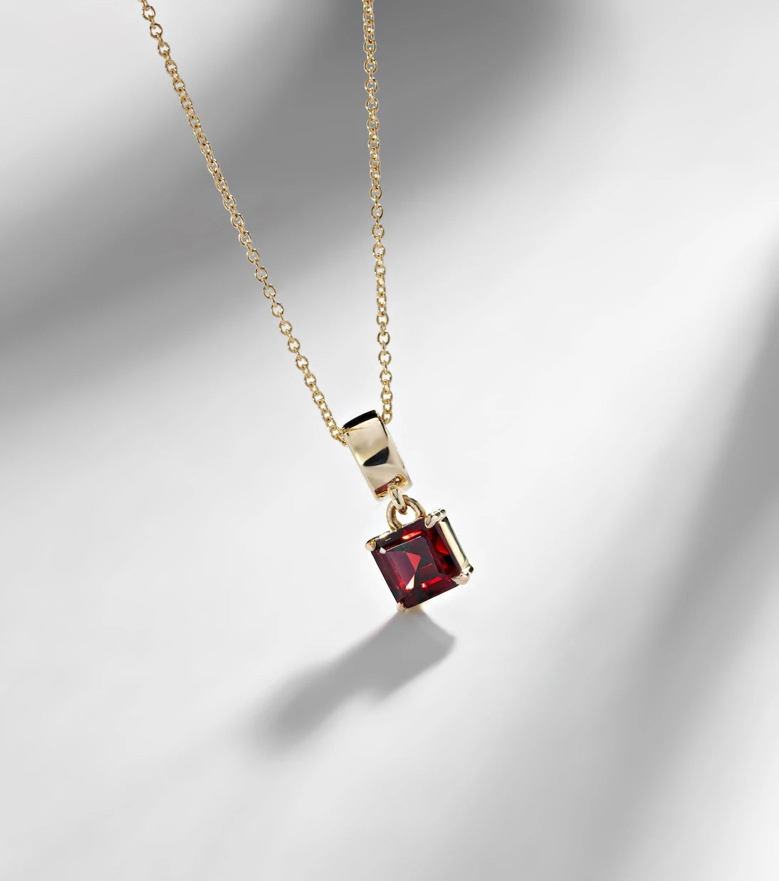 Stone and Strand - 10kt gold charm necklace with garnet