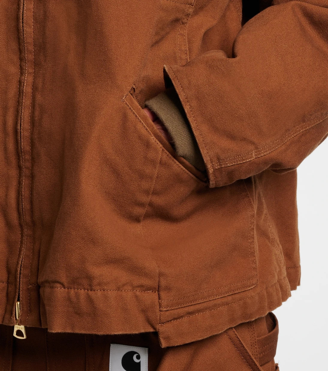 Sacai - جاكيت بافر من قماش الكانفاس القطني بتعاون مع Carhartt