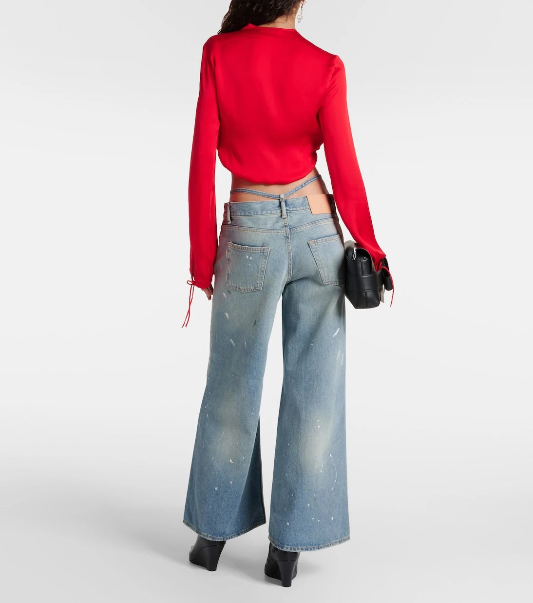 Acne Studios - بنطال جينز ترافالغار الفضفاض بقصة منخفضة ومصاب بتلاشي اللون